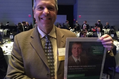 During NAIOP Pittsburgh's 25th Annual Awards Banquet in 2018, Quatchak smiles with a NAIOP ad in the Pittsburgh Business Times featuring him.