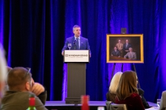 Quatchak makes a speech during his retirement dinner. Next to him is a commissioned portrait of the four CEC Founding Principals.